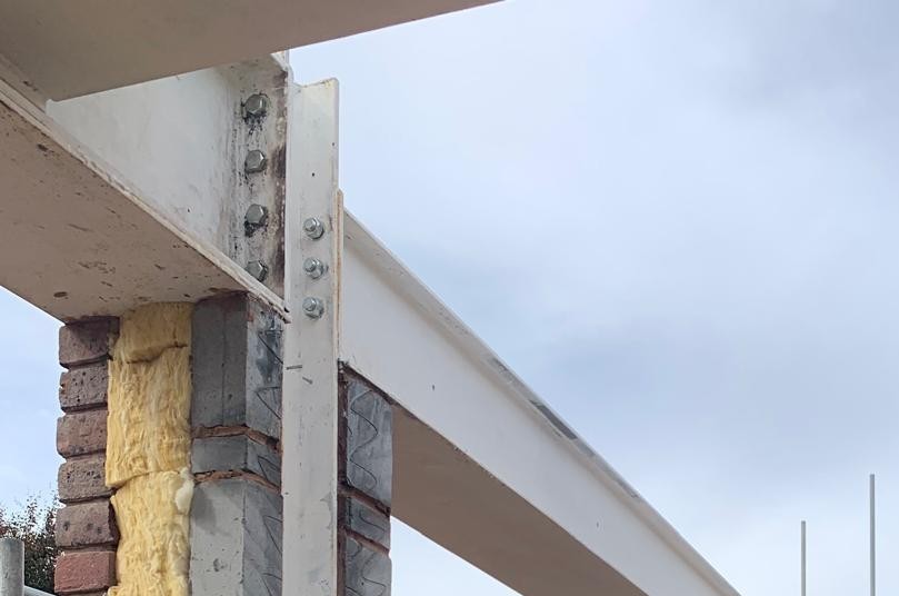 Steel beam connected to structural column for residential construction